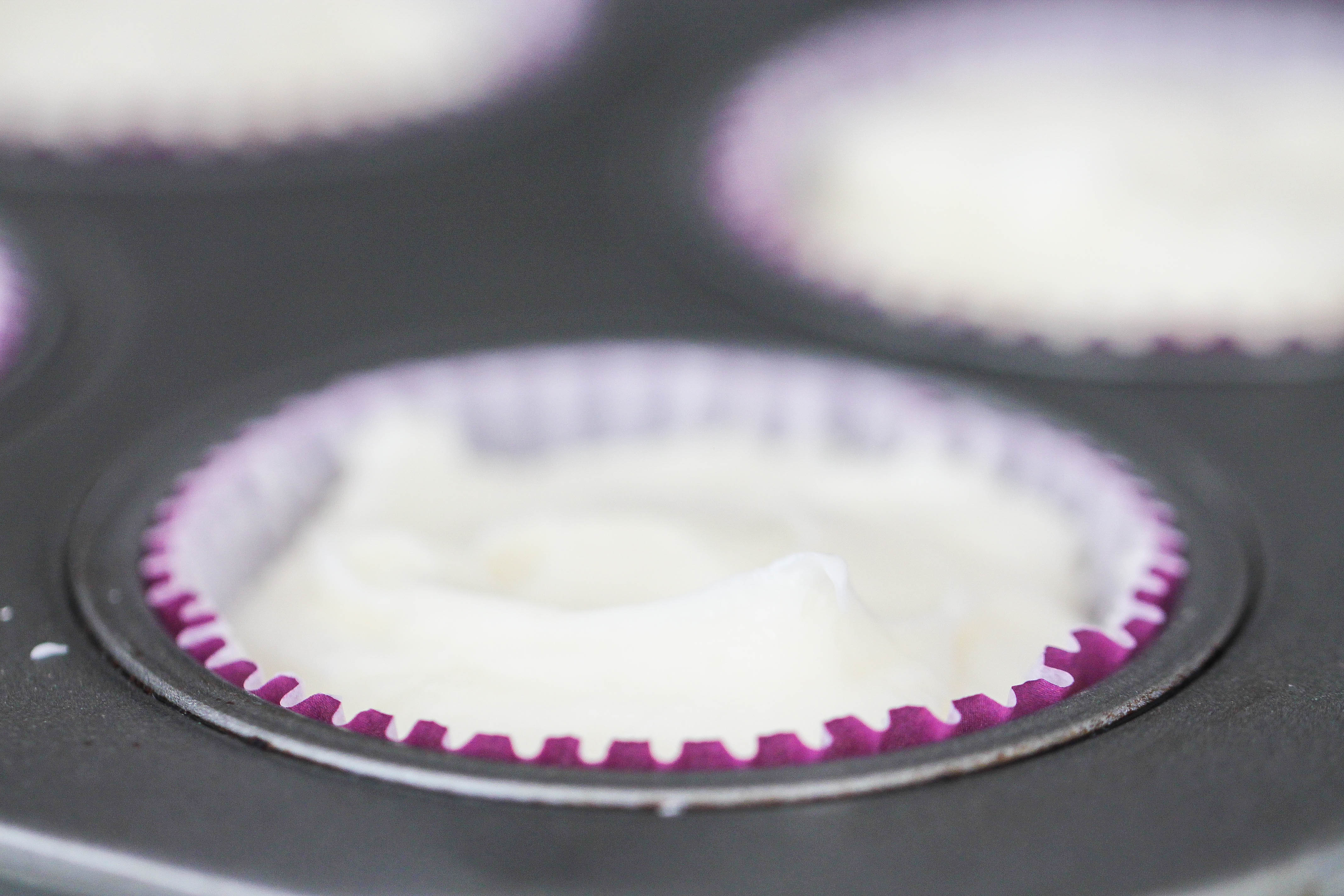 Muffin tin with a cupcake liner filled with Cream Cheese Mixture