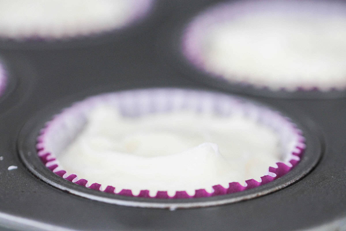 Muffin tin with a cupcake liner filled with Cream Cheese Mixture