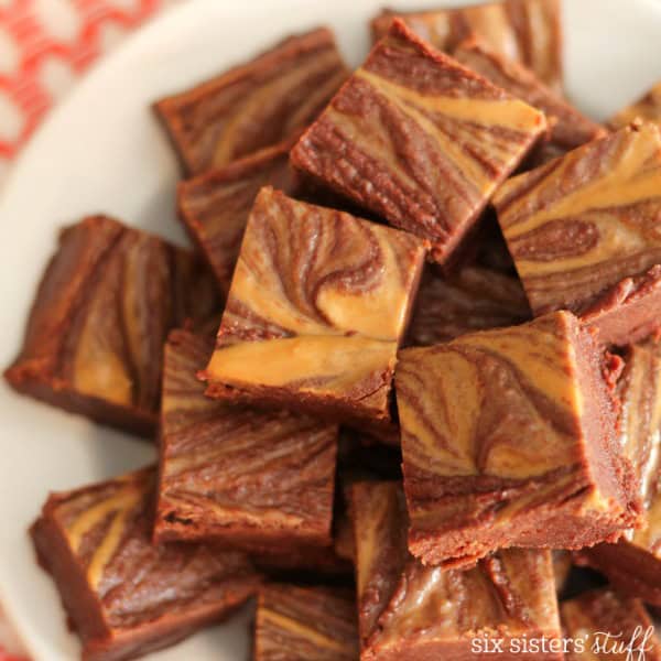 A plate of square chocolate brownies with a marbled pattern, featuring chocolate and caramel swirls.