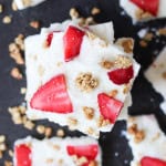 Squares of Strawberry Granola Yogurt Bark stacked on top of each other.