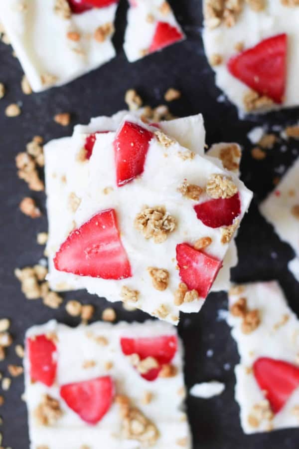 Squares of Strawberry Granola Yogurt Bark stacked on top of each other.