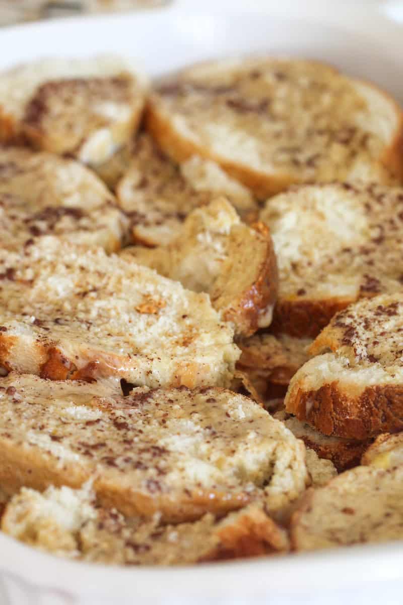 Cinnamon mixture on top of french bread in a baking dish