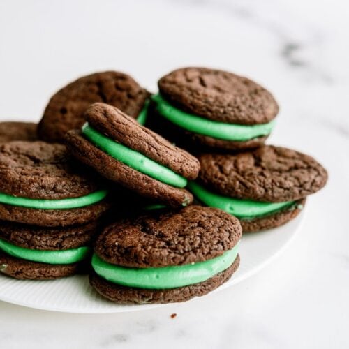 Grasshopper Sandwich Cookies stacked on a serving plate.