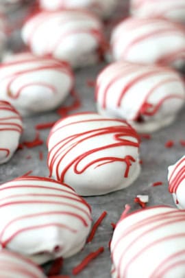 White chocolate covered Red Velvet Cake Bites lined up in rows.