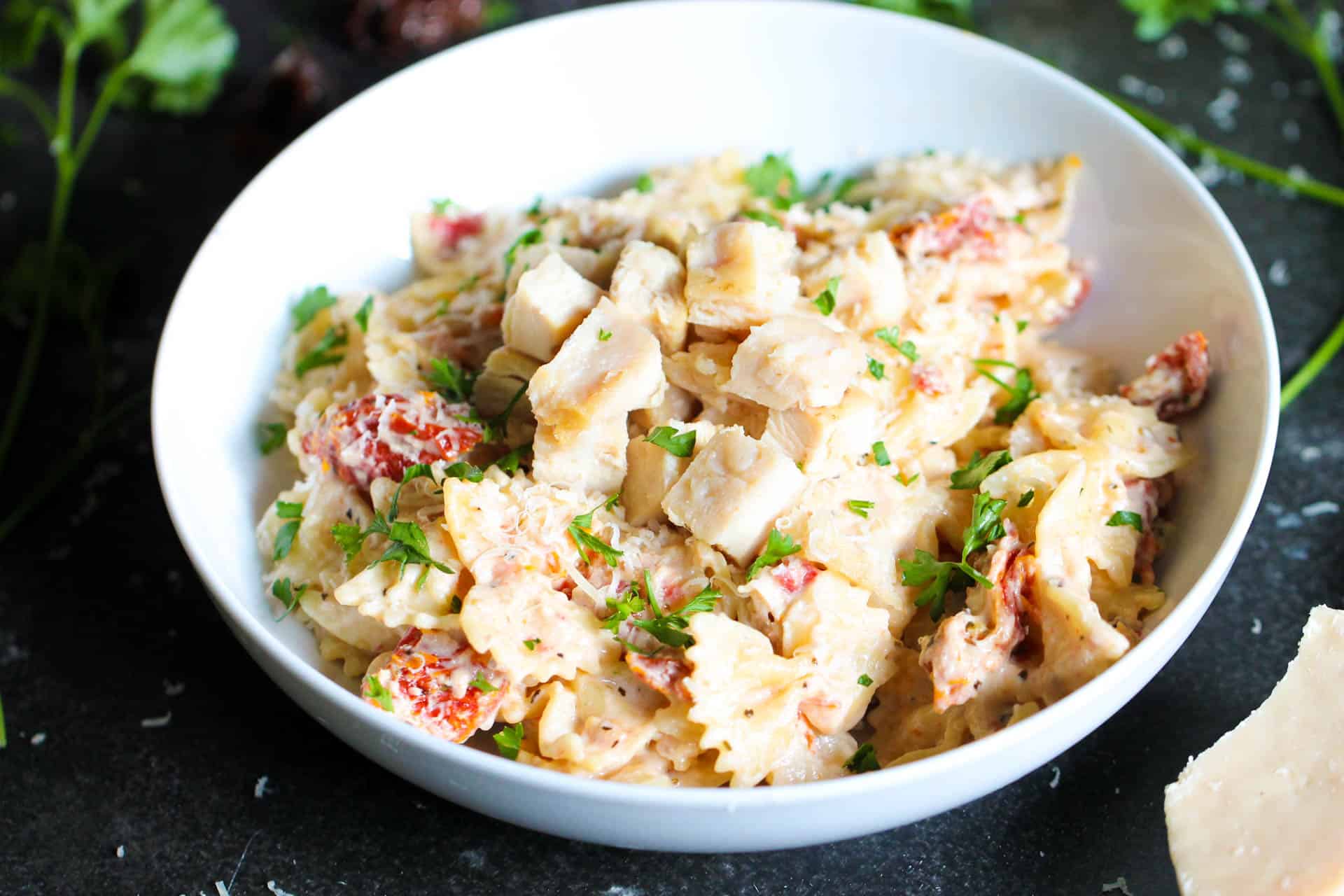 Tuscan Pasta Freezer Meal topped with Chicken in a white bowl