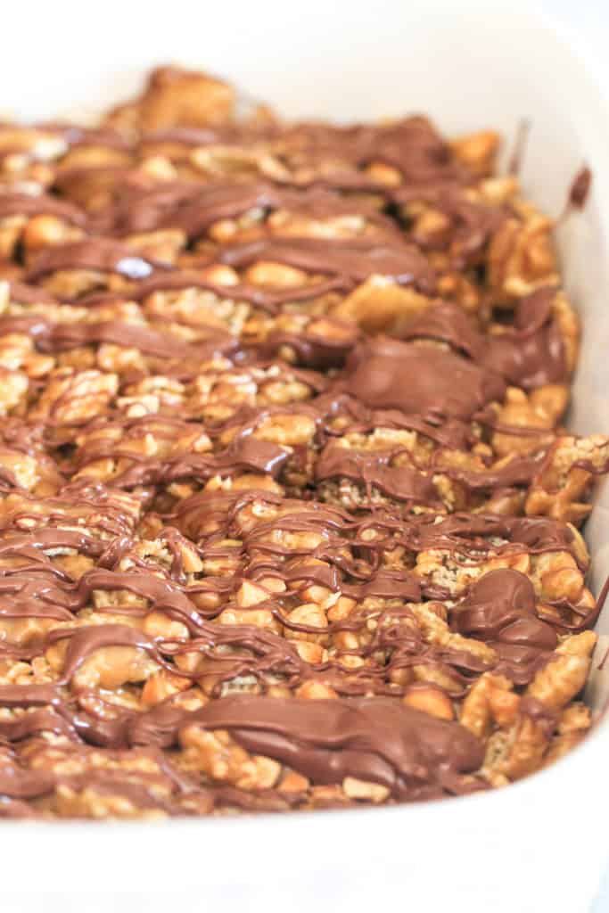 No Bake Peanut Butter Chex Bars in a baking dish with chocolate drizzled on top.