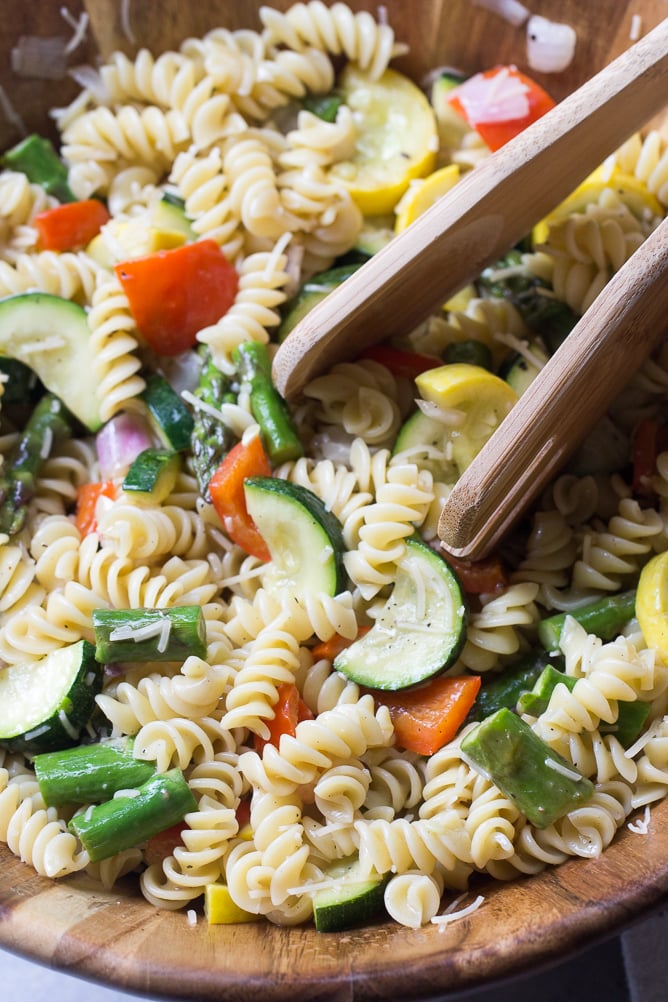 Roasted Veggie Pasta Salad on a large bowl with salad tongs