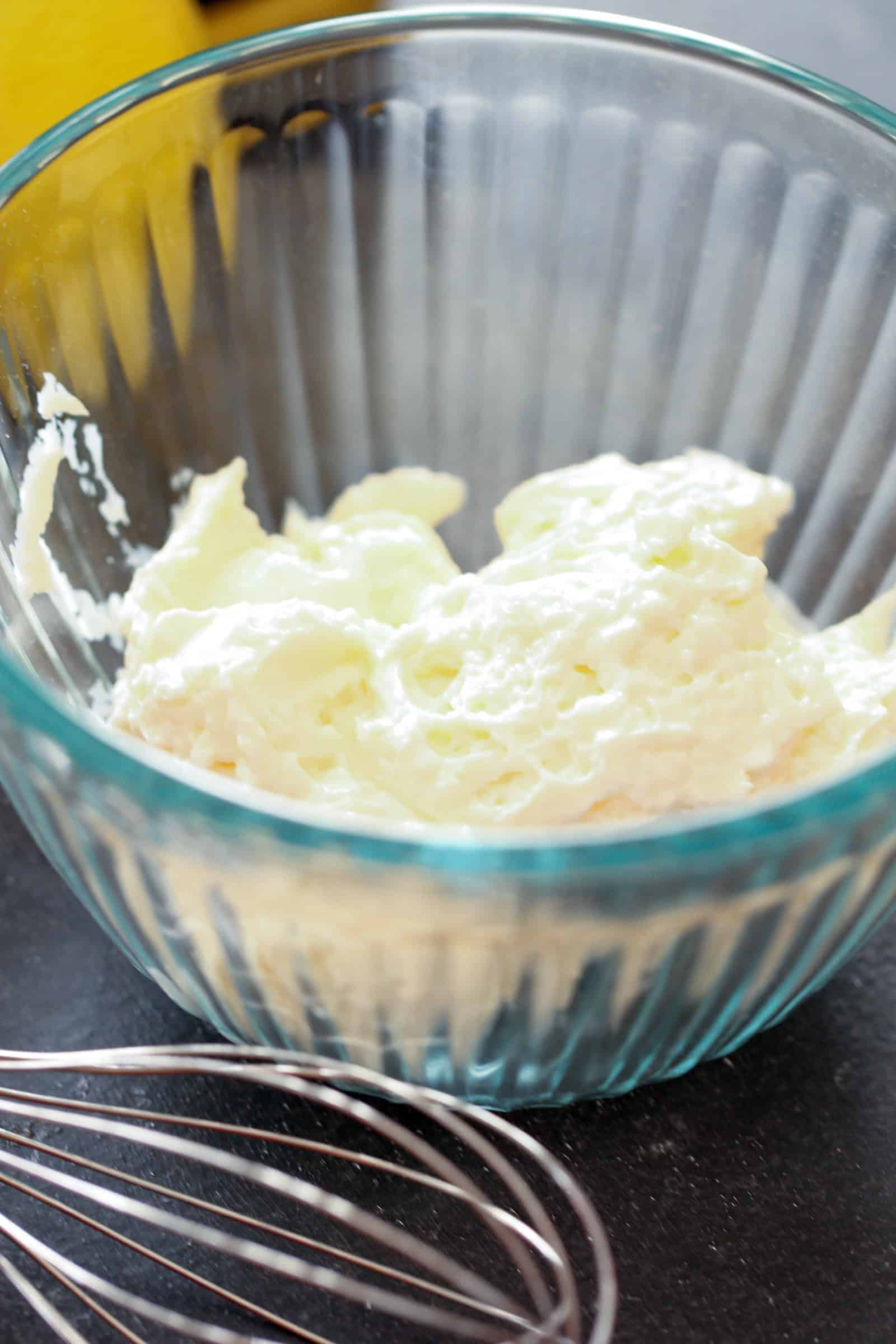 Mayo in the bottom of a glass mixing bowl with a whisk