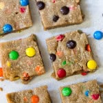 Peanut Butter M&M Blondies cut into squares on a white background.