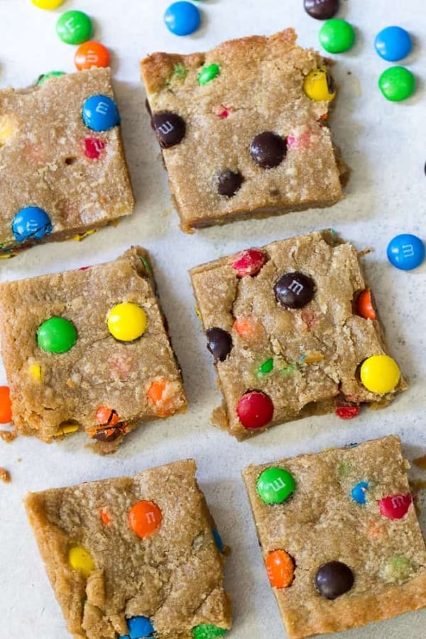 Peanut Butter M&M Blondies cut into squares on a white background.