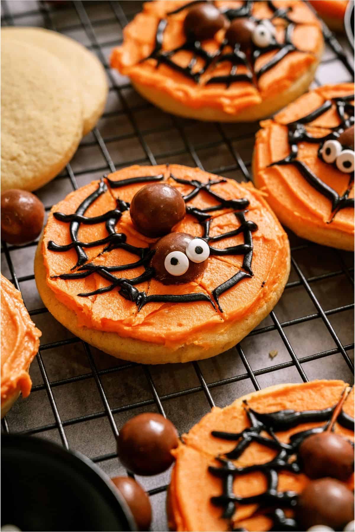 Halloween spider web sugar cookies decorated with chocolate and candy eyes.