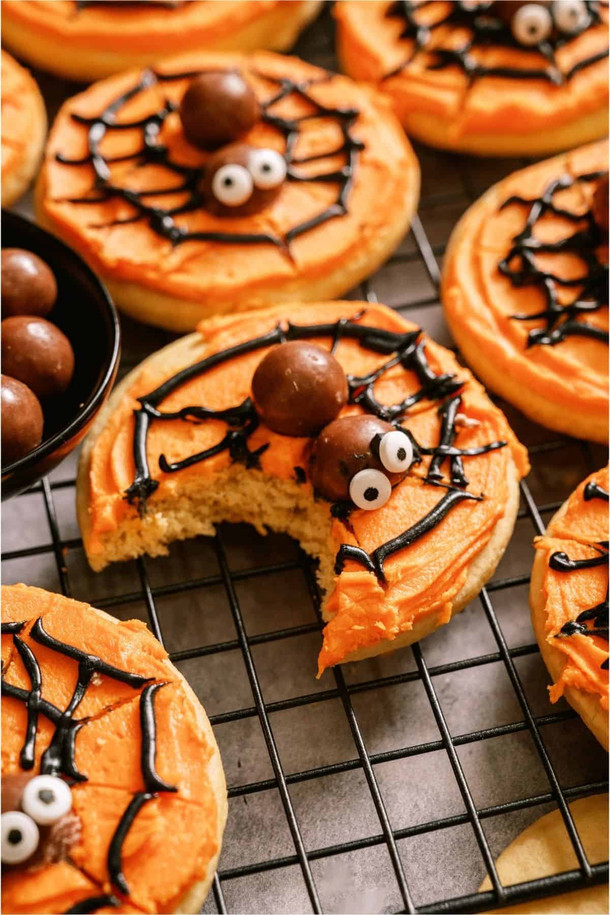 Halloween spider web sugar cookies with candy eyes and chocolate web decoration.