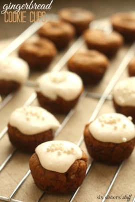 Small round cookies topped with white icing and sprinkles, arranged on a wire rack.