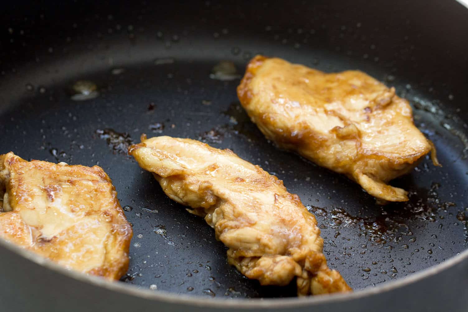 Skillet with chicken breasts in it