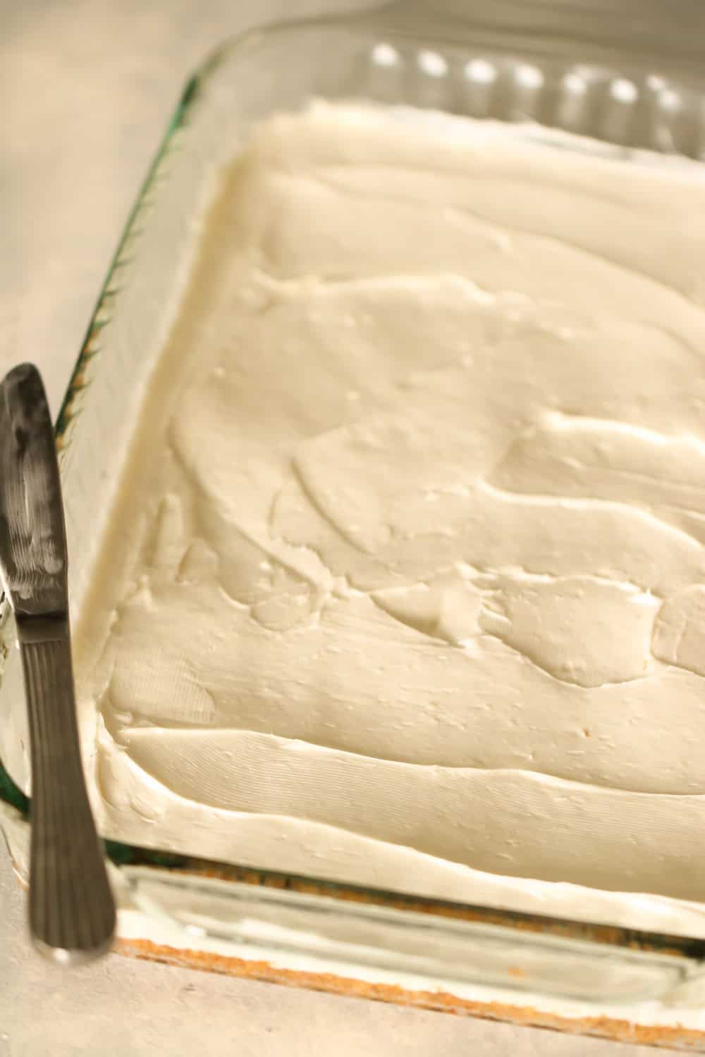 cream cheese layer spread of crust in 9x13 glass pan with a knife