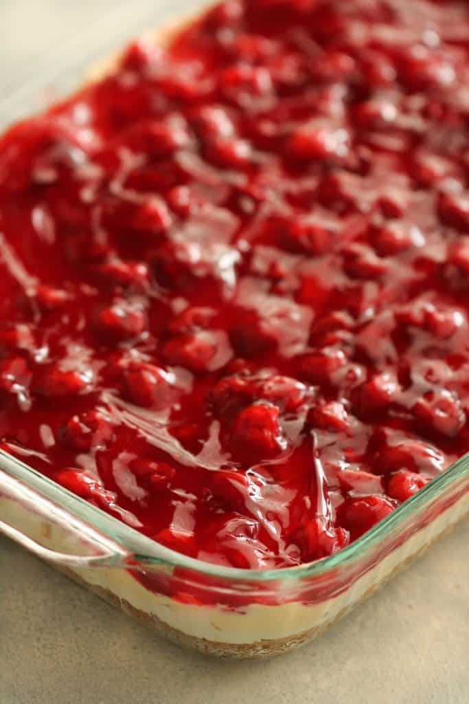 Cherry layer on top of pudding layer in baking dish.