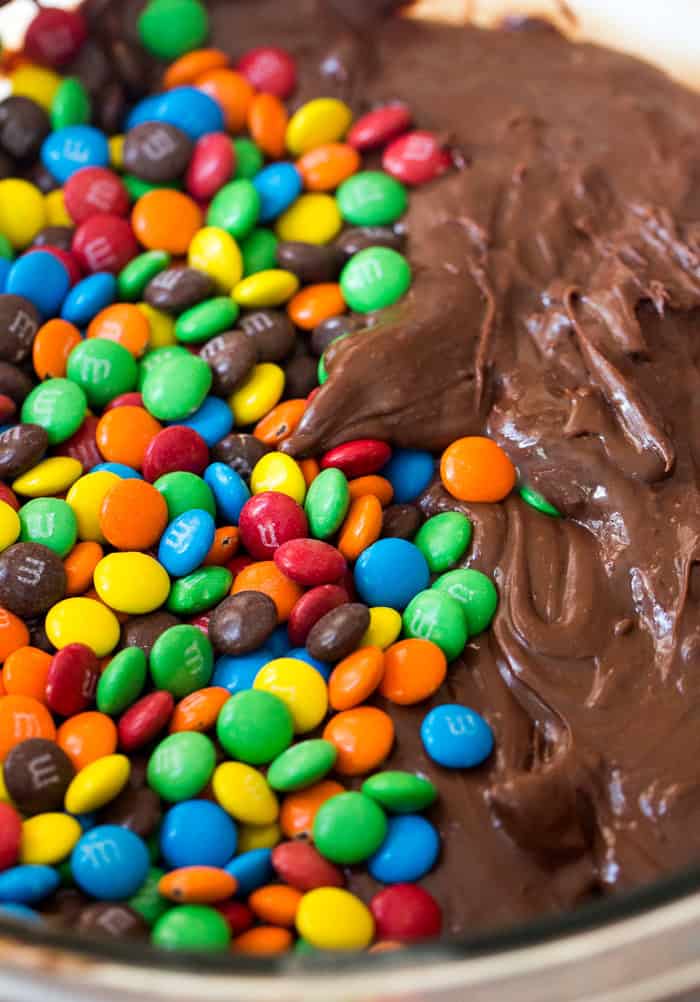 Mini M&M's added to melted chocolate chips in a sauce pan.