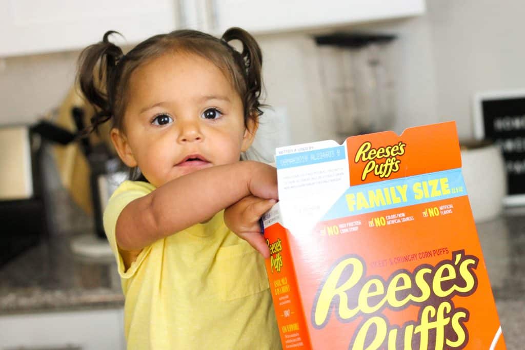 Little girl with box of Reese's Puffs