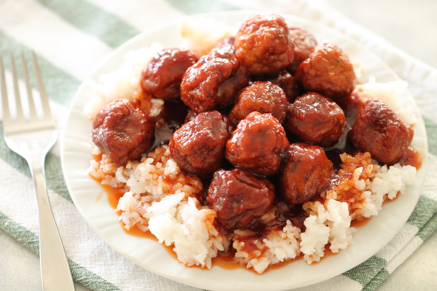 Instant Pot Sweet and Tangy Meatballs served over white rice on a plate