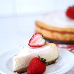 Lion House copycat cheesecake on a plate with a strawberry slice on top