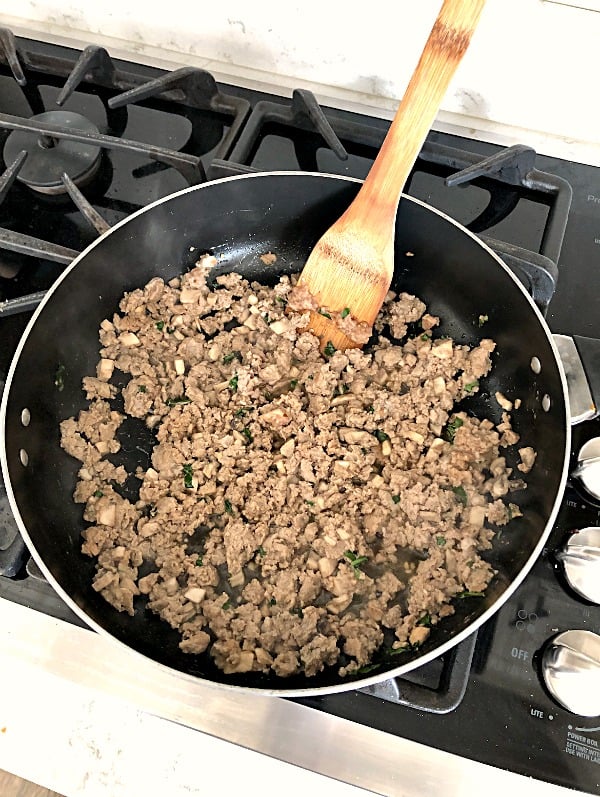 ground chicken cooking in a skillet on the stove top
