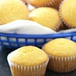 Copycat Famous Dave’s Cornbread Muffins in a basket with two muffins in front.