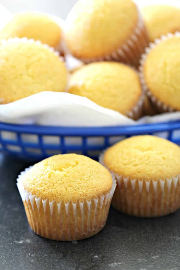 Copycat Famous Dave’s Cornbread Muffins in a basket with two muffins in front.