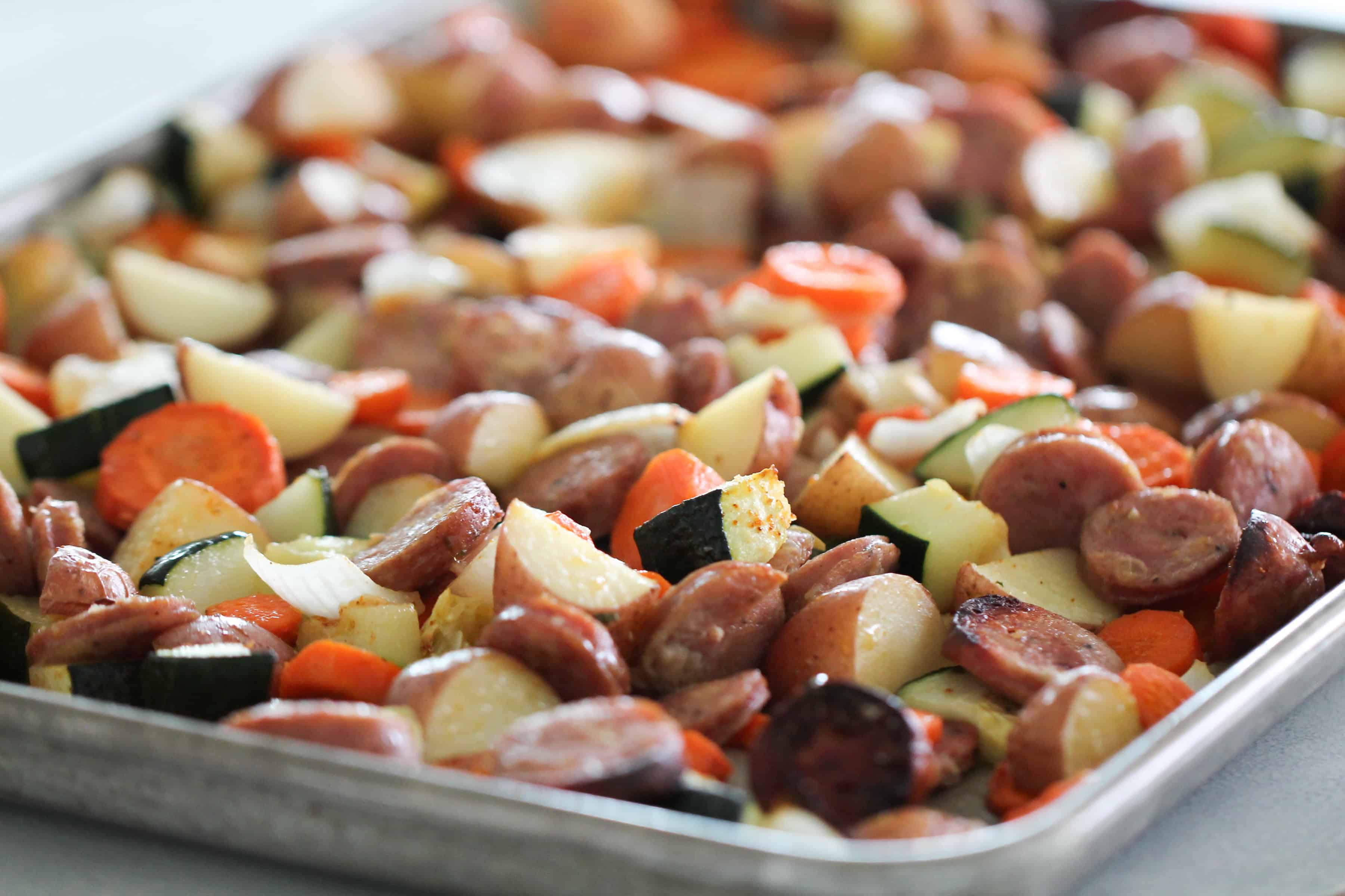 Full view of sausage and vegetables cooked in pan.