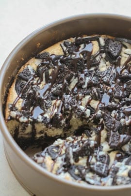 Cheesecake Factory Oreo Cheesecake in a springform pan with crushed oreos on top.
