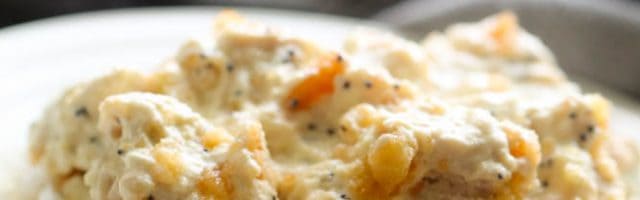 poppy seed chicken casserole served over rice on a plate