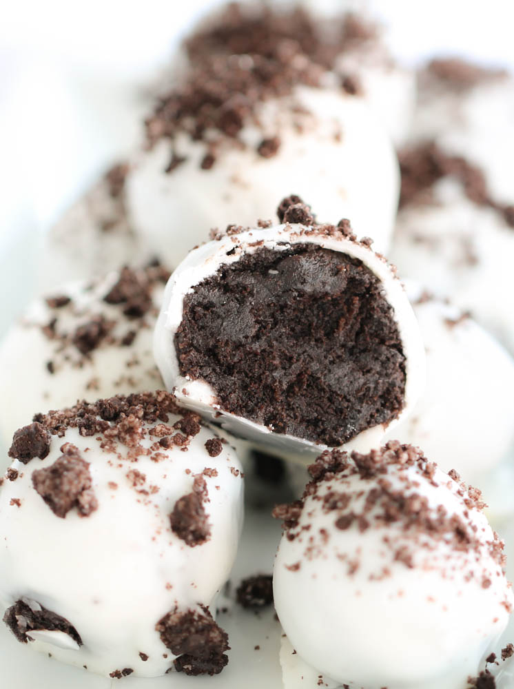 Oreo Cookie Truffles with one showing the truffle filling