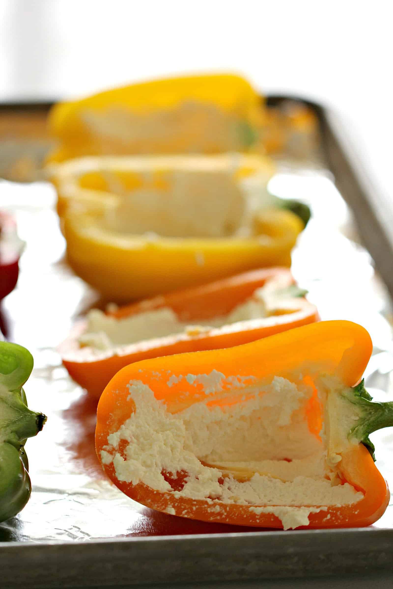 Bell Peppers with ricotta cheese on a baking sheet.