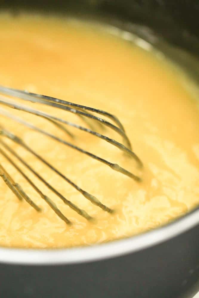Lemon curd in a large mixing bowl with a whisk.