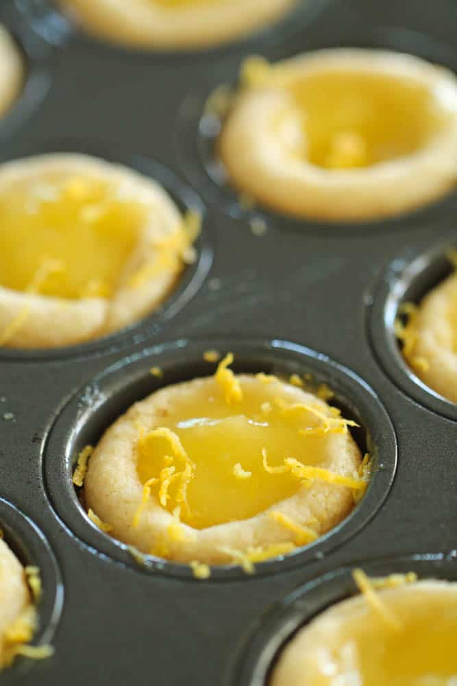 Fresh lemon zest on top of Lemon Bar Cookie Cups in muffin tin.