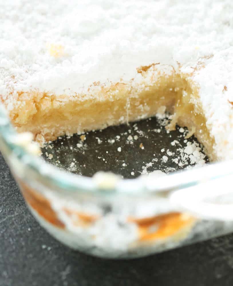 Lemon bars in pan topped with powered sugar