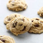 Chocolate Chip Pudding Cookies on a countertop with 1 cookie stacked on some.