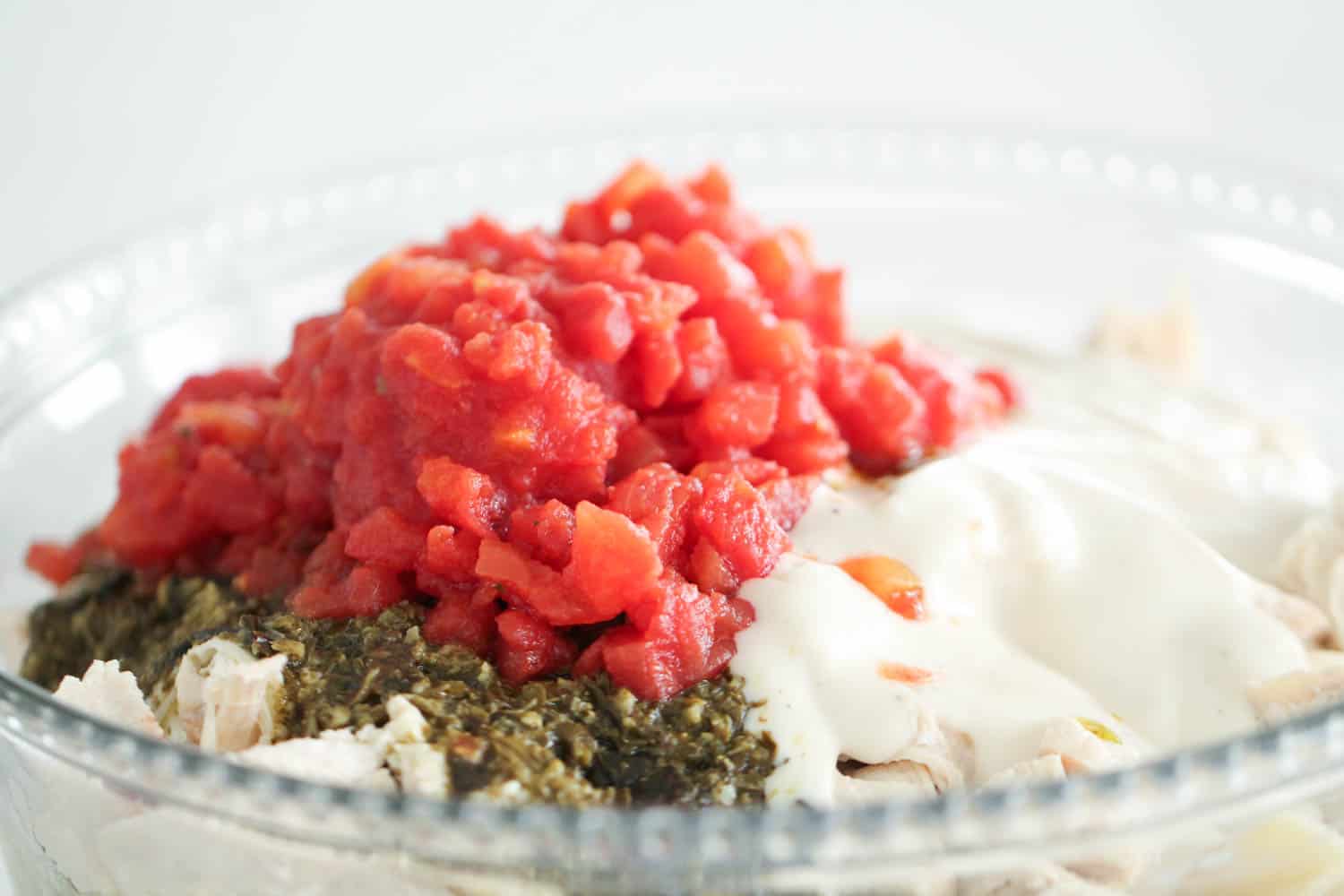 pesto chicken casserole ingredients in glass bowl