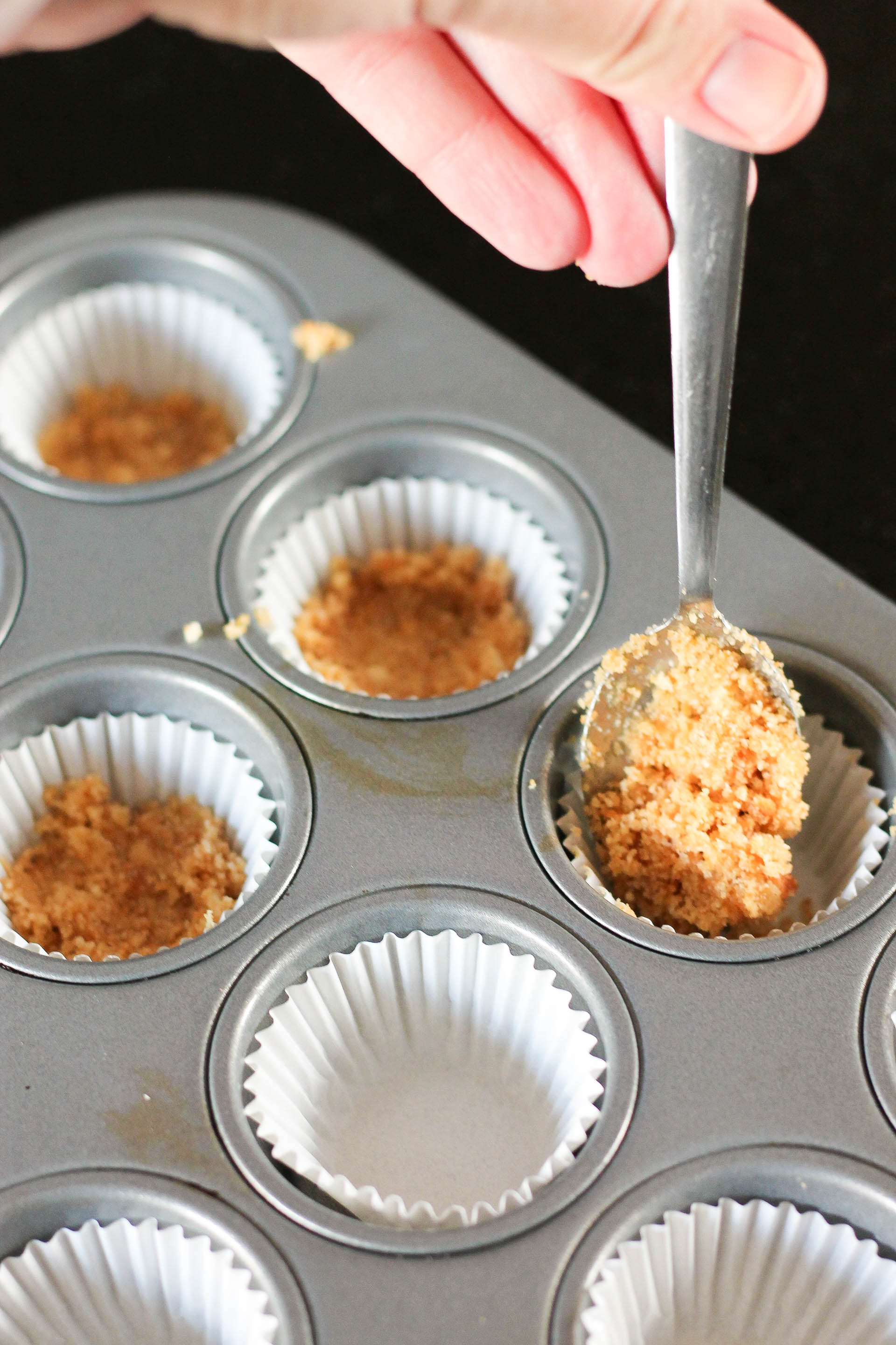 Vanilla Wafer Crust being spooned into mini muffin liners