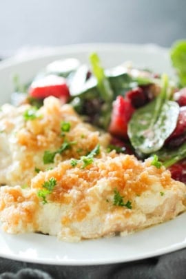 Two pieces of Ritz Chicken on a plate with salad on the side.