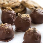 Chocolate Chip Cookie Truffles on a countertop with cookie crumbs sprinkled on top of the truffles.