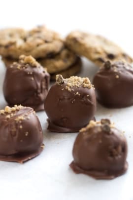 Chocolate Chip Cookie Truffles on a countertop with cookie crumbs sprinkled on top of the truffles.