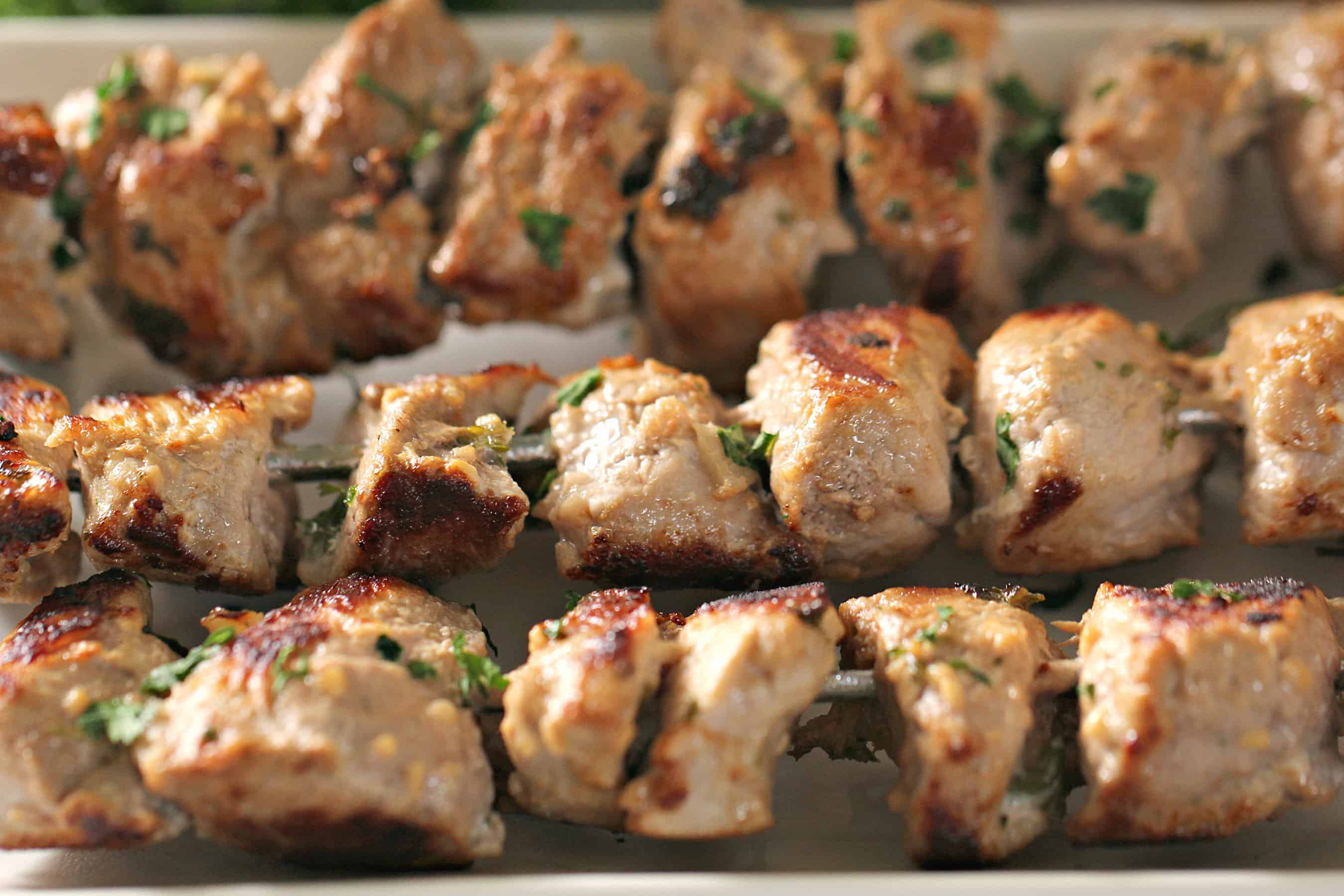 Mediterranean Pork Kabobs on skeweres sitting on a serving plate