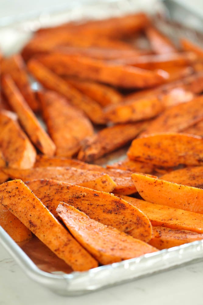 sweet potato wedges seasoned and spread out on a baking sheet