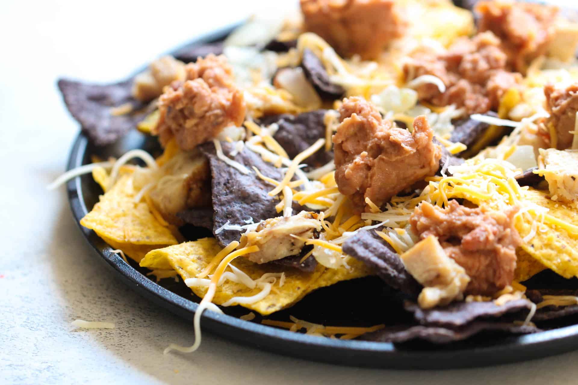 layer of Copycat Fiesta Chicken Nachos on a plate