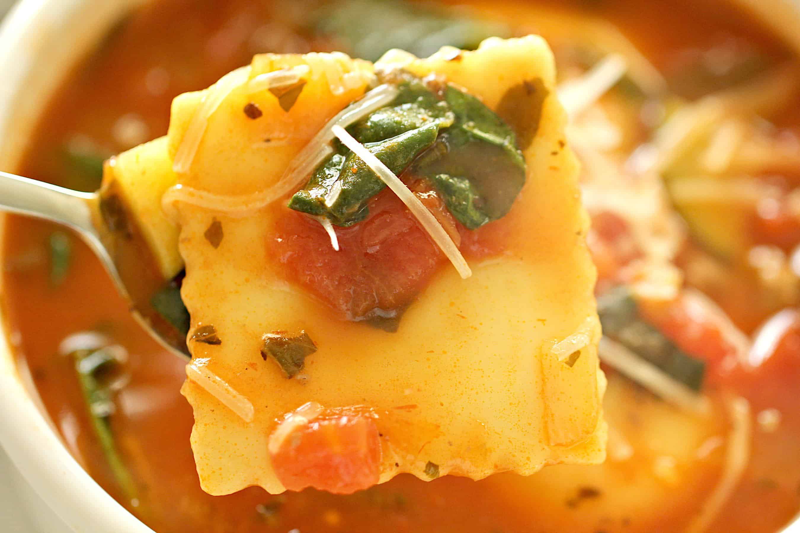 Ground Turkey Sausage Ravioli Soup in a bowl with a spoon holding out one ravioli