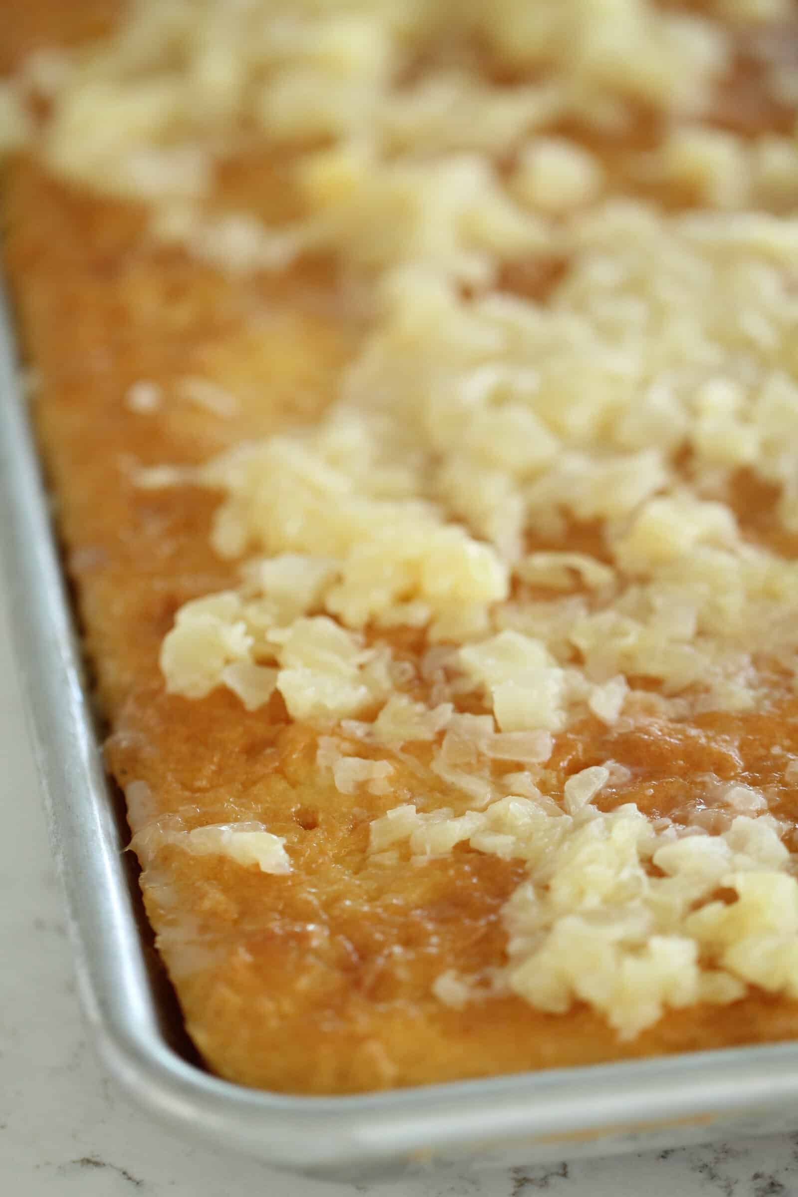 Cream of coconut poured onto yellow cake