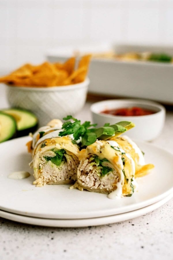 avocado chicken enchiladas cut in half on a plate