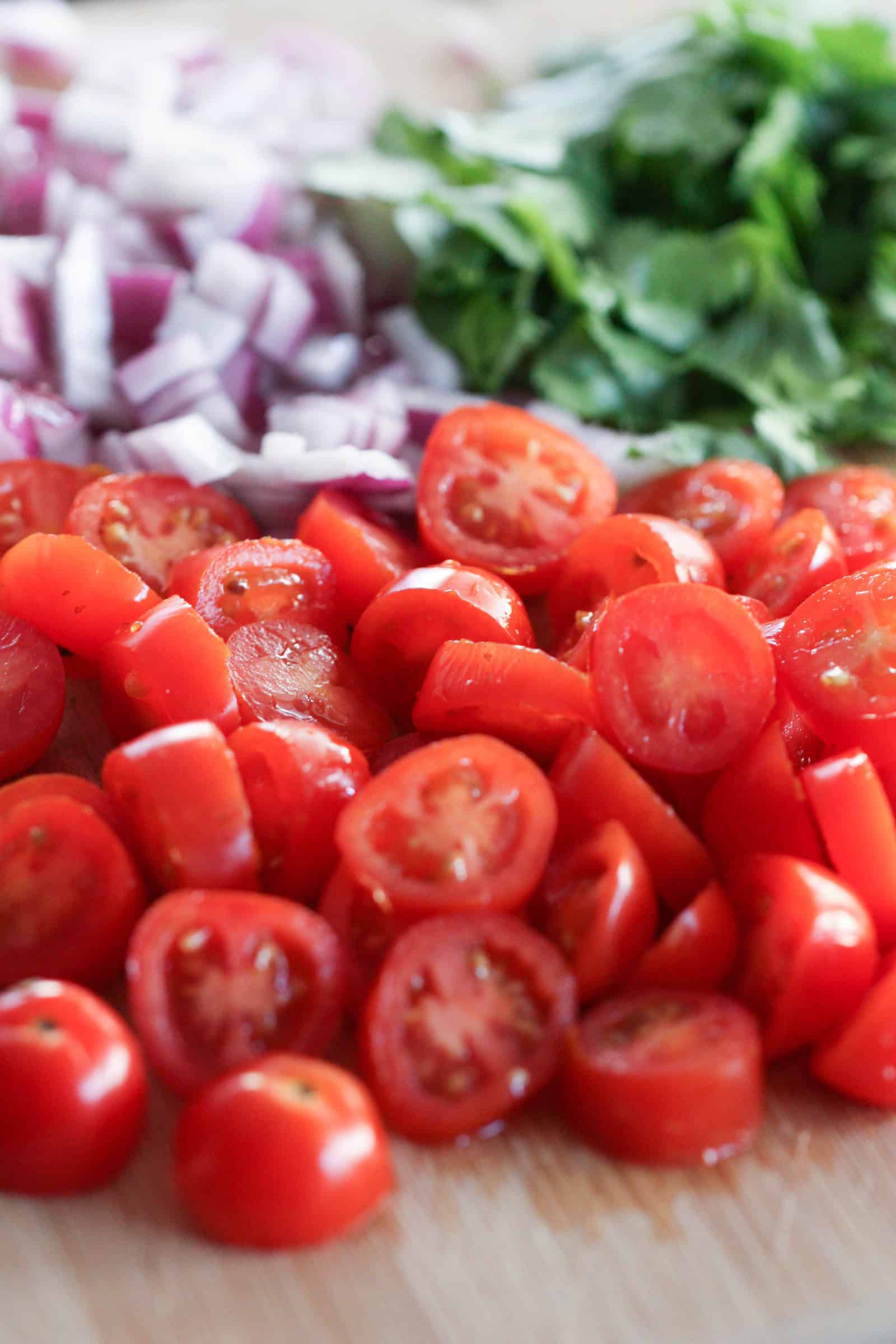 Cherry tomatoes sliced in half with onions and shredded lettuce