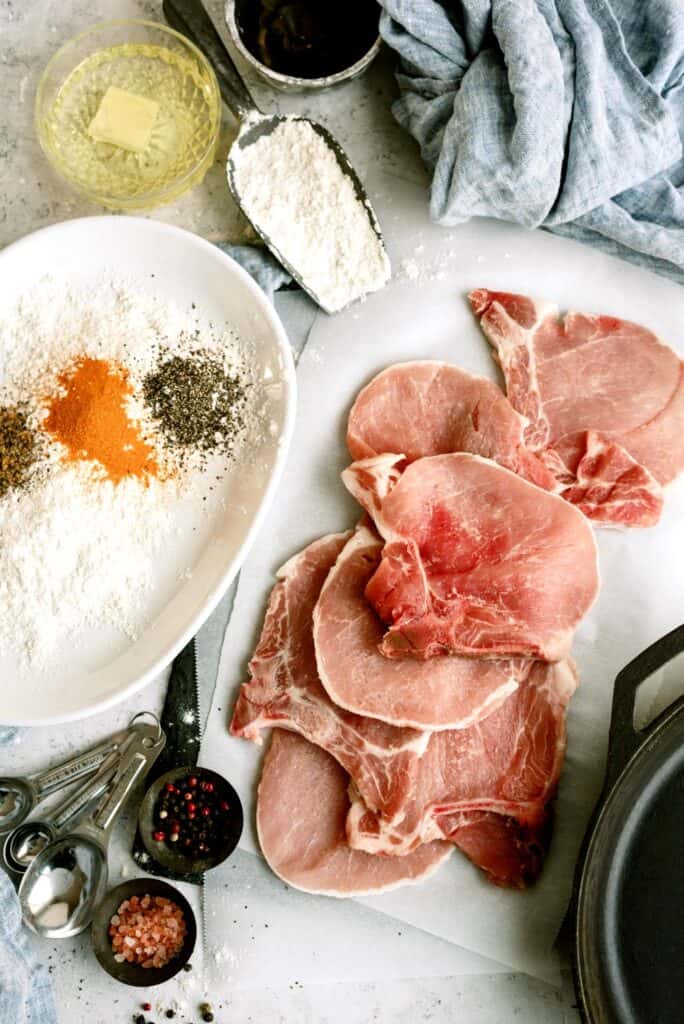 Raw pork chops ready to be dredged in flour