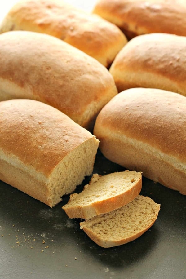 loaves of bread on cutting board with twoslices